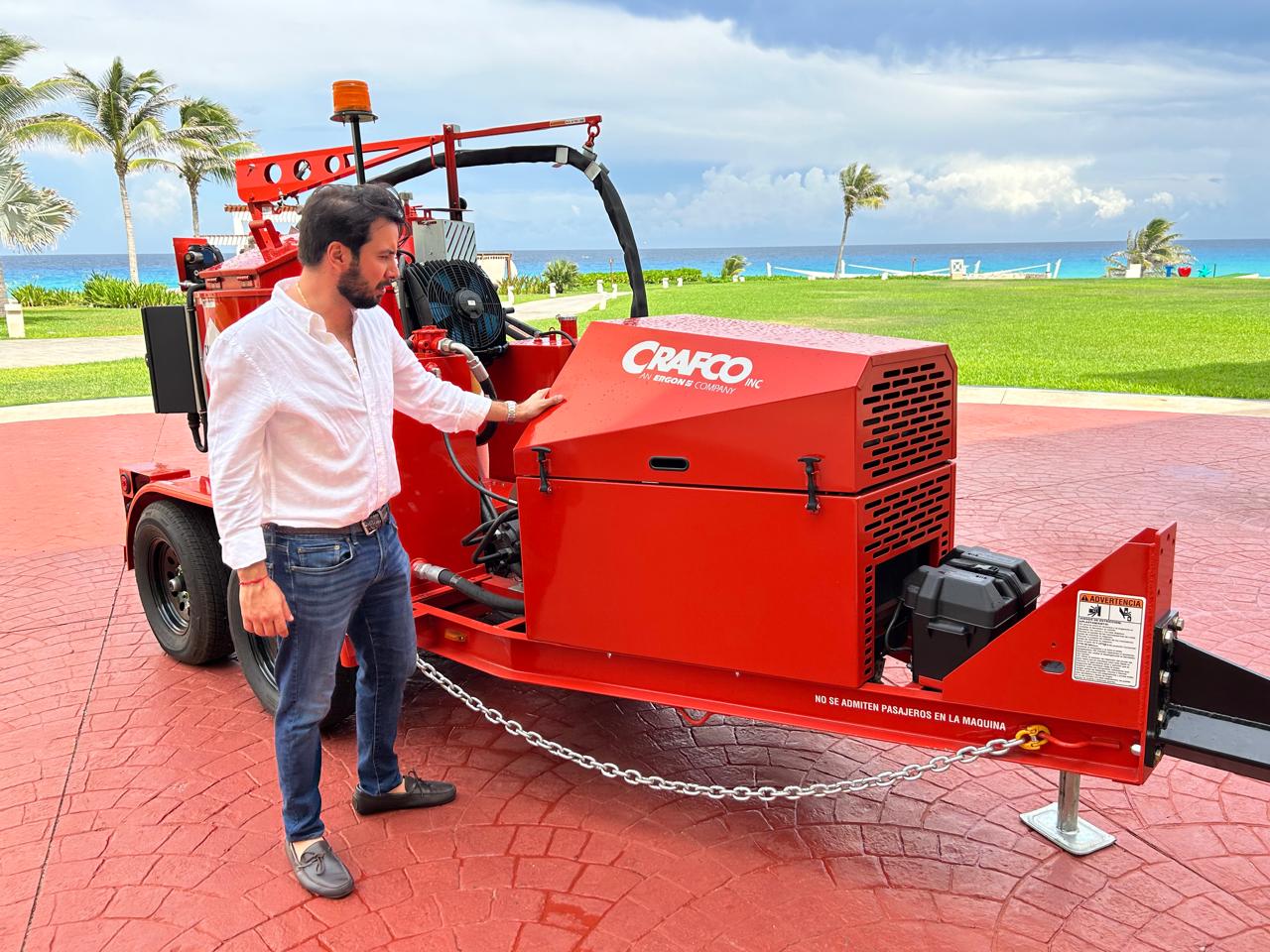 Hassan López revisando el sistema hidráulico de una selladora de grietas Crafco